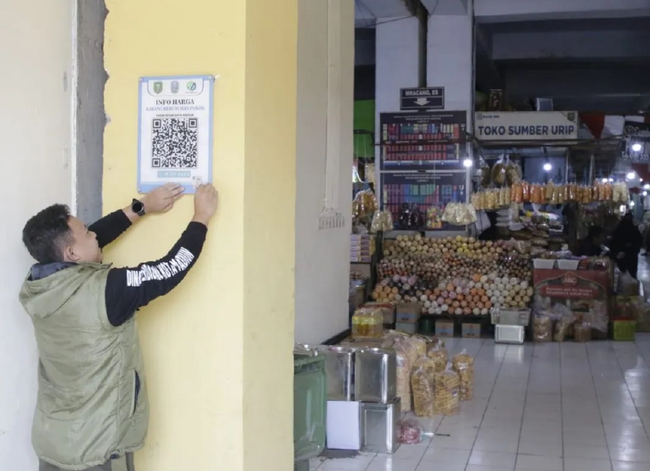 Seorang petugas Dinas Perdagangan Kota Madiun memasang kode batang ‘Barcode’ untuk layanan pantau harga bahan pokok di Pasar Besar Madiun, Jawa Timur. SP/ MDN