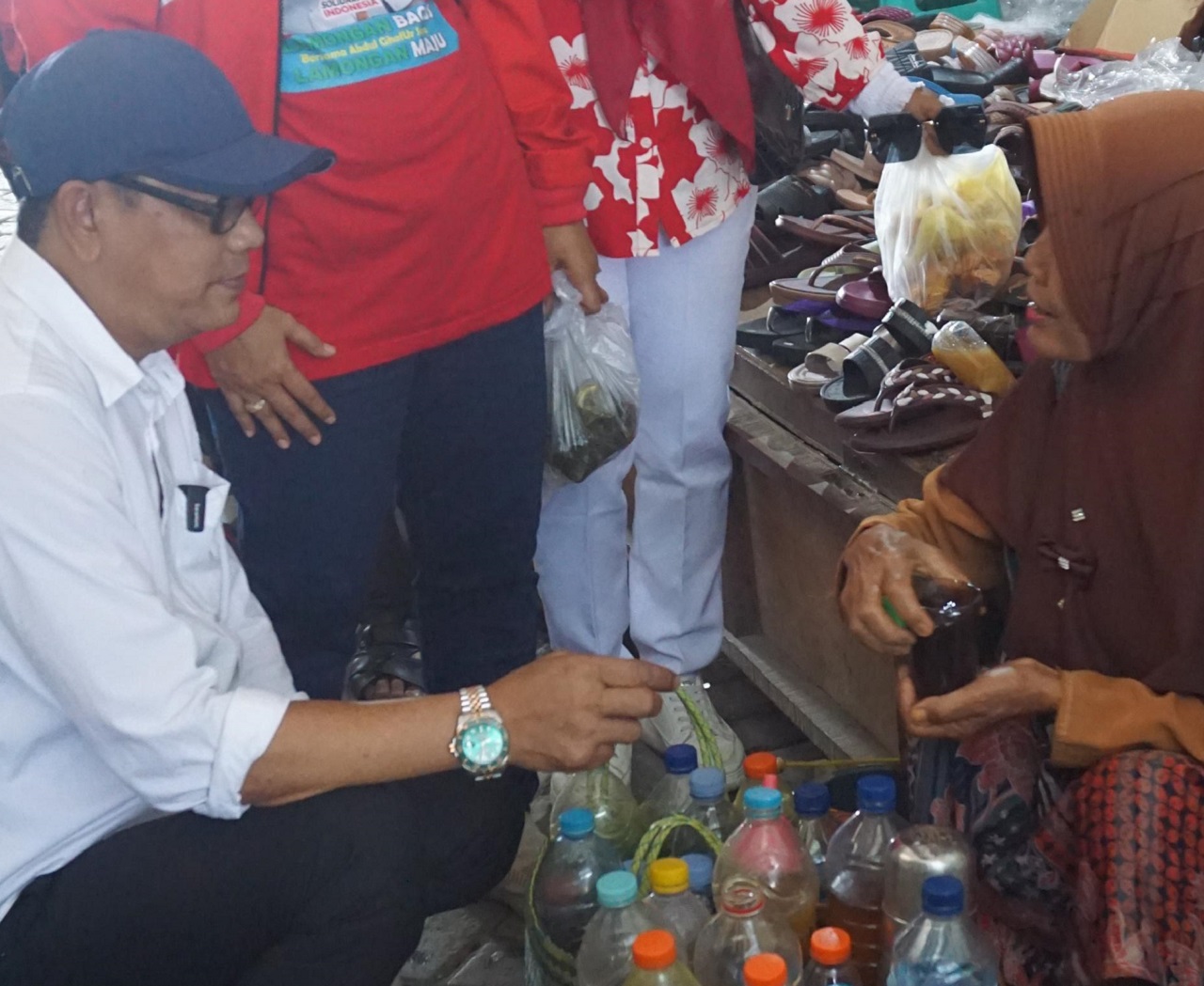 Caption: Cabup nomor urut 1 Abdul Ghofur mengedepankan Akhlakul Kharimah dalam setiap beraktivitas, salah satunya ia perlihatkan saat menyapa pedagang dengan cara duduk jongkok. SP/ MUHAJRIN 