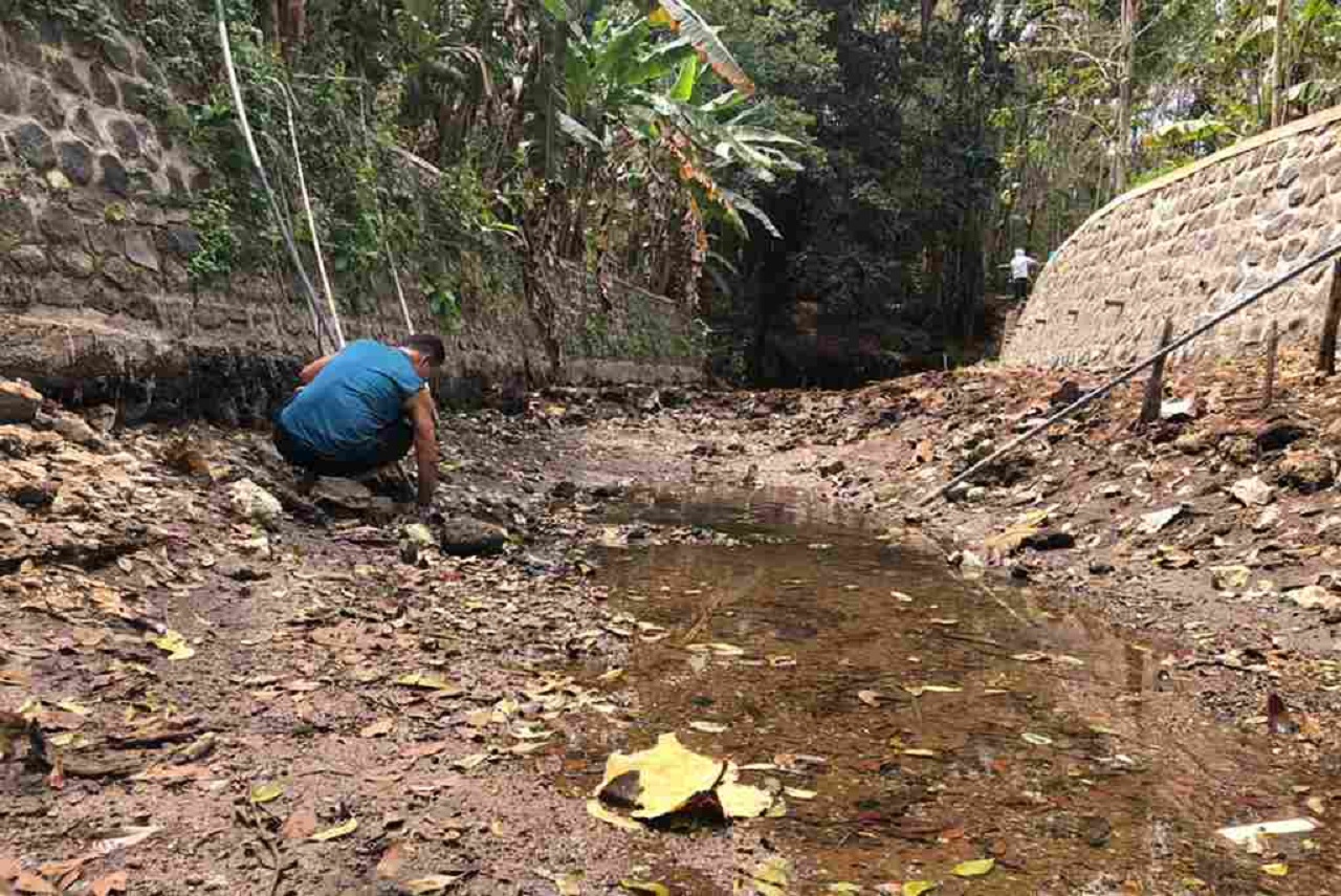 Salah satu warga yang tengah memperbaiki pipanya untuk mendapatkan air bersih dari sumber yang mengering. SP/ MLG