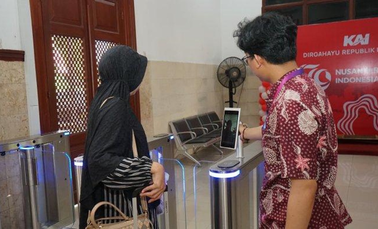 Petugas KAI membantu penumpang KA Pandalungan melakukan boarding dengan fasilitas face recognition boarding gate di Stasiun Jember. SP/ JBR