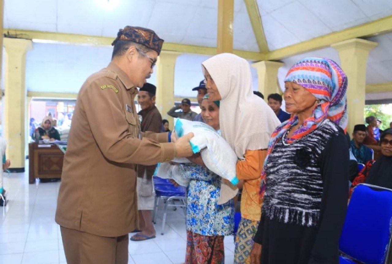 Pj Sekda Kabupaten Probolinggo Heri Sulistyanto memberikan secara simbolis beras cadangan pangan kepada warga penerima manfaat, yakni warga miskin. SP/ PRB