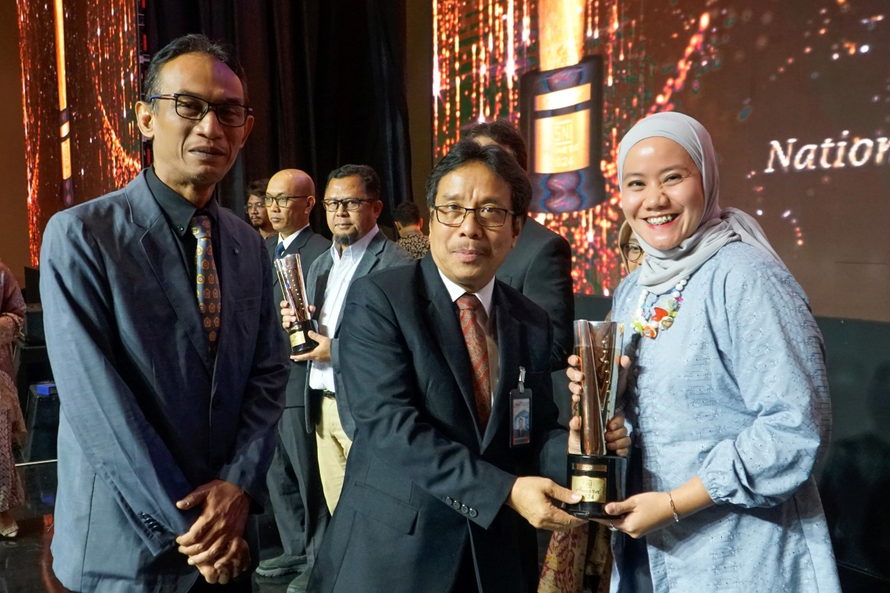 Ajeng Dwi Utami, Department of Management System & Business Process Excellence SIG (kiri) saat menerima trofi peringkat Emas penghargaan SNI Award 2024 dari Kukuh S. Achmad, Kepala Badan Standardisasi Nasional, pada ajang 19th National Quality Award of In
