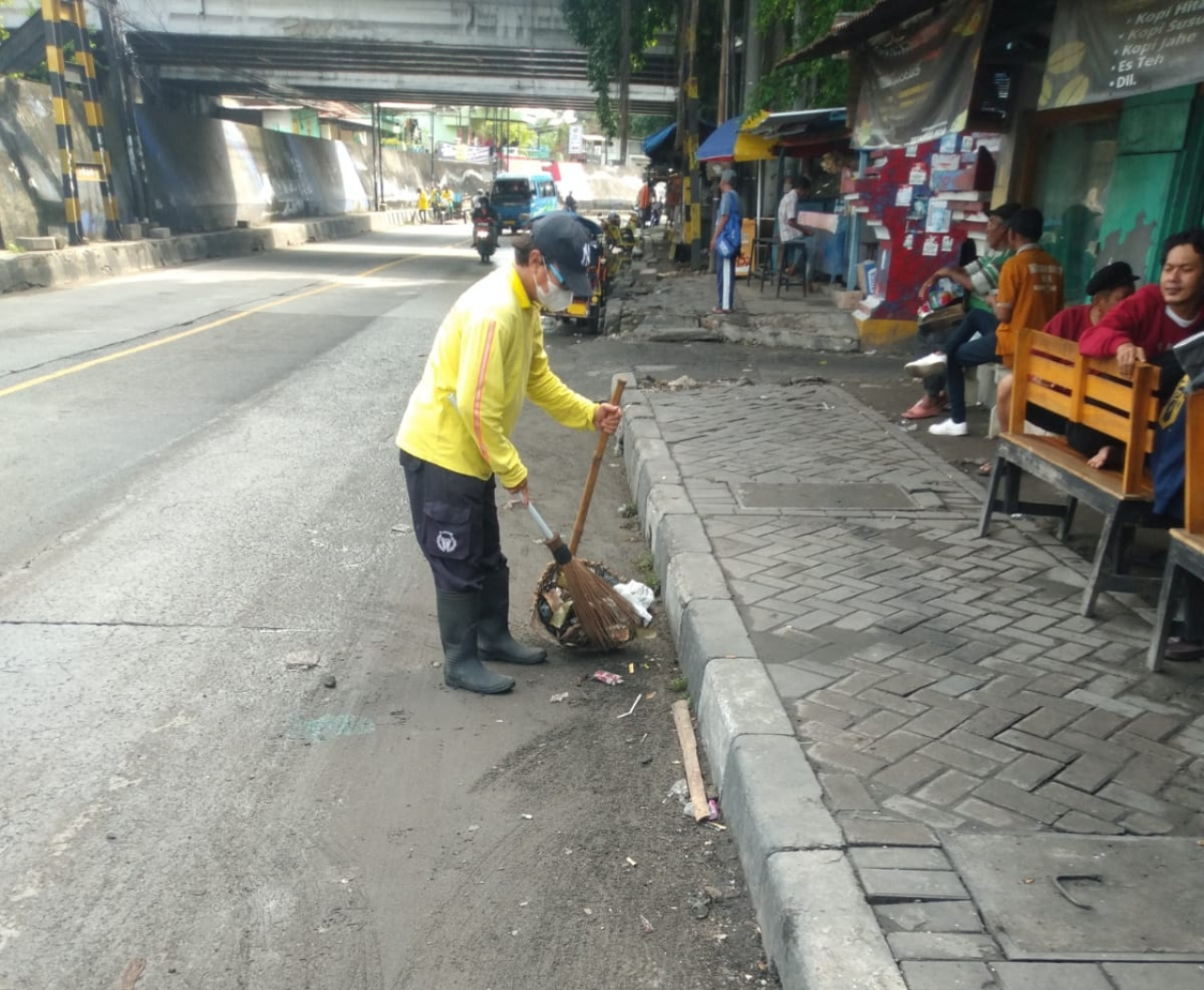 Petugas kebersihan tengah membersihkan sampah yang berserakan di tepi jalan wilayah Babat Lamongan. FOTO:SP/IST
