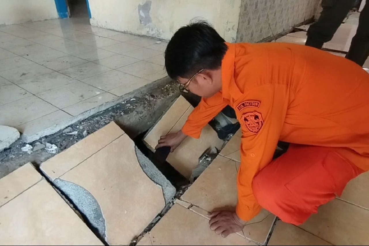 Petugas BPBD Pacitan melihat lantai rumah warga yang rusak, akibat tanah gerak di Desa Karanganyar Kecamatan Kebonagung Kabupaten Pacitan, Jawa Timur. SP/ PCT