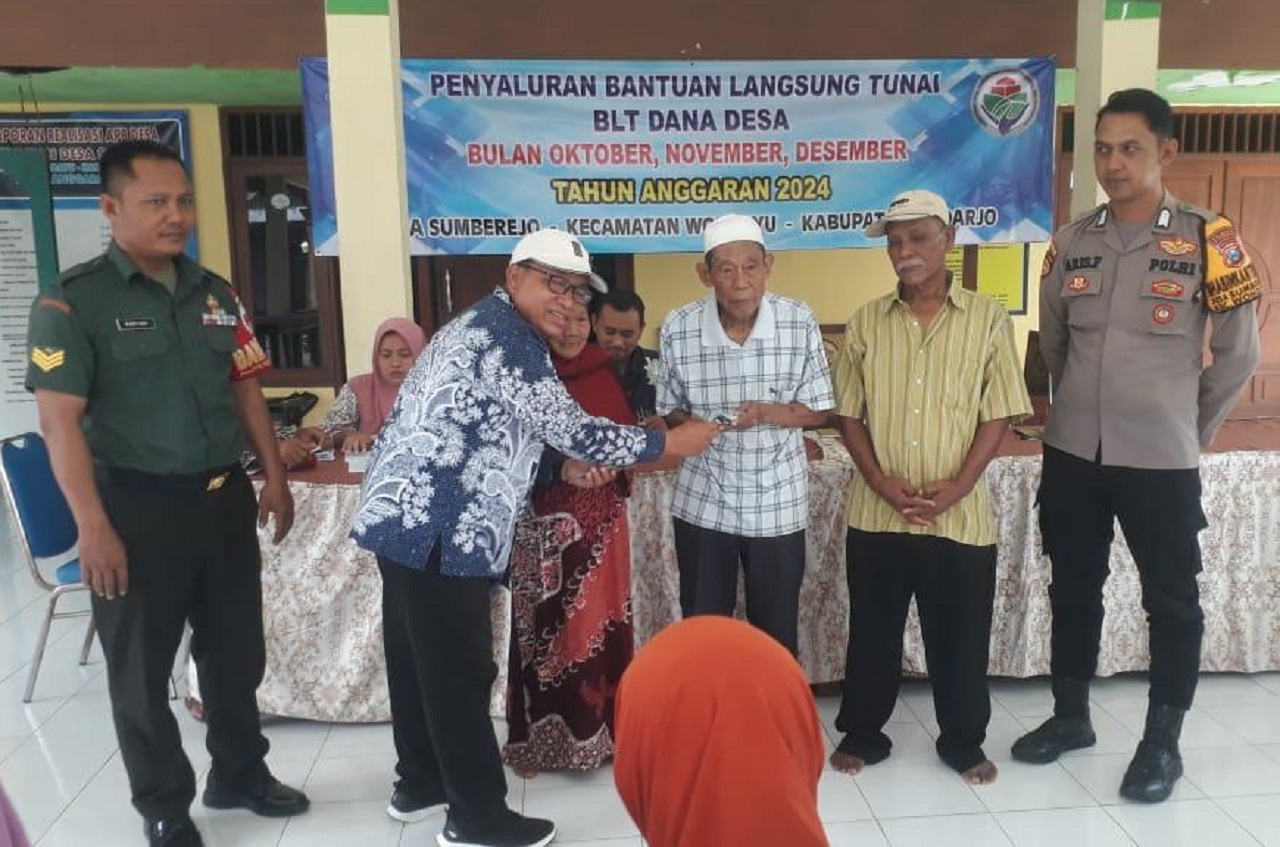 Kades Sumberrejo, Haji Sahar Maulana, saat menyerahkan Bansos BLT-DD pada warga penerima bantuan. SP/ JUM