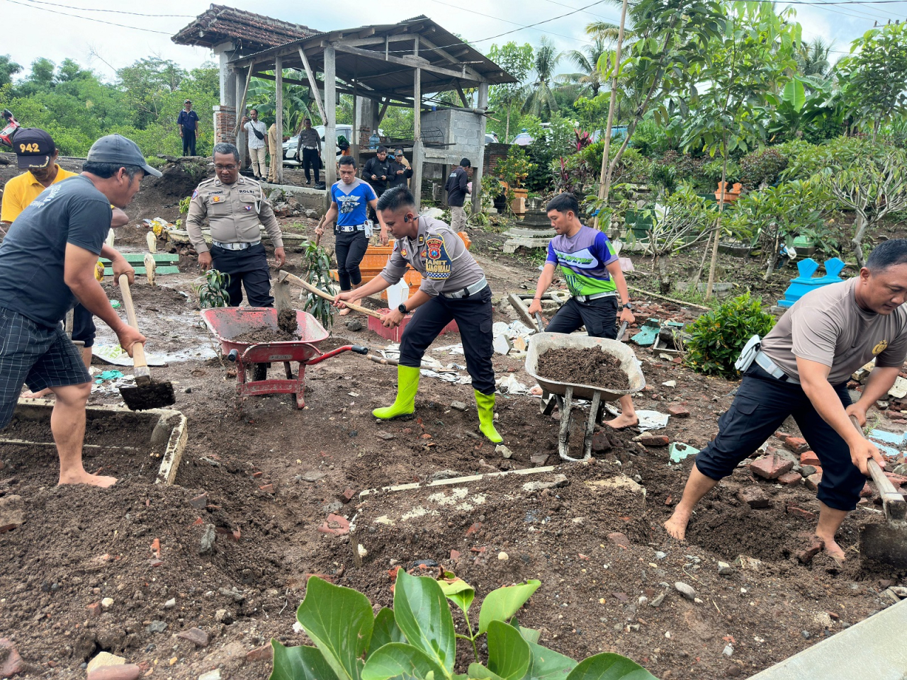 Petugas dibantu warga membenahi fasum berupa makam yang terimbas banjir beberapa waktu yang lalu. SP/Lestariono