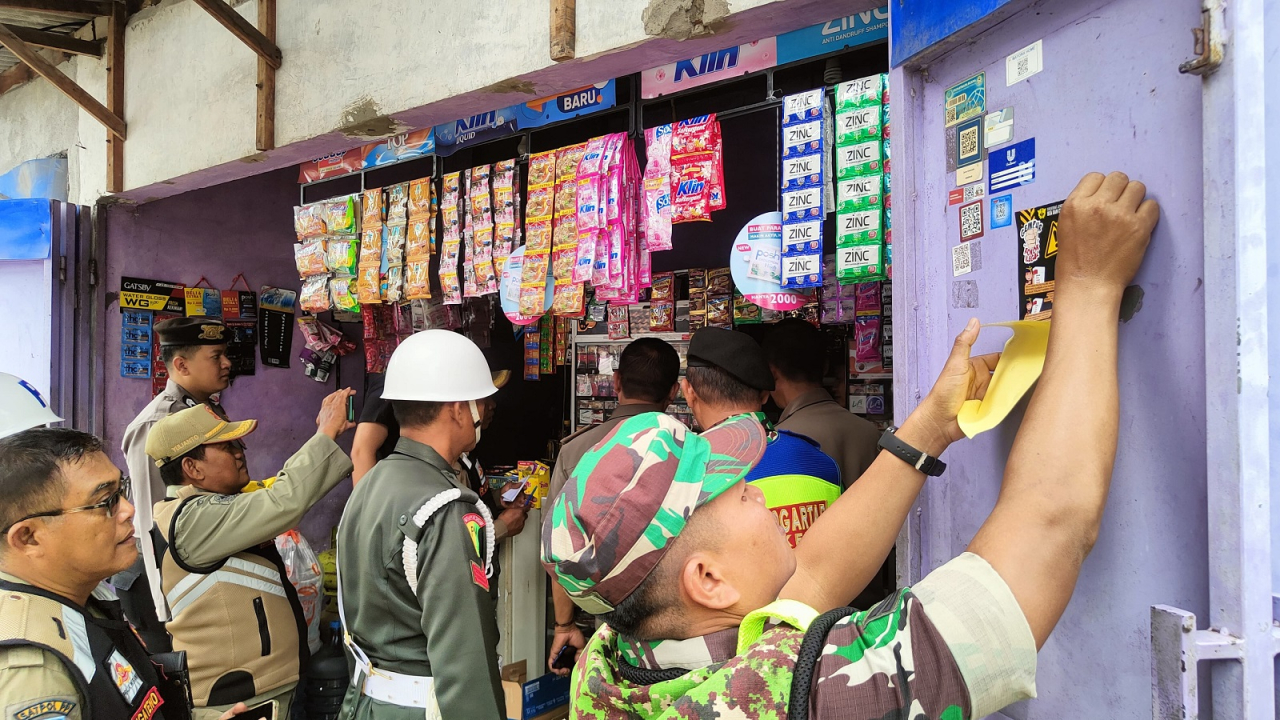 Petugas Satpol PP Kota Mojokerto dan petugas Bea Cukai dan petugas tim gabungan saat memeriksa keaslian pita cukai rokok saat razia.