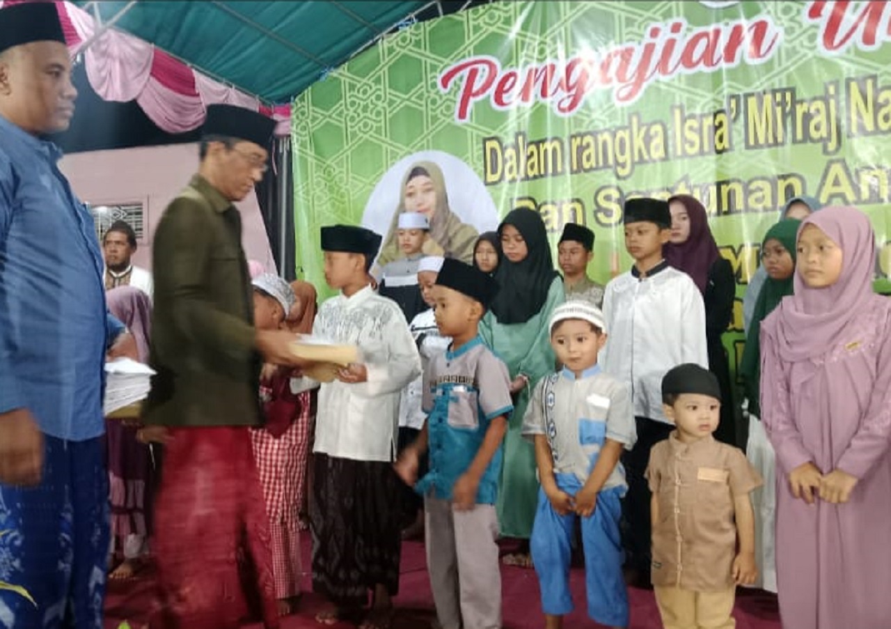 Takmir Masjid Al-Amin Ustadz Kosi'in Alwi menyerahkan santunan kepada anak yatim piatu. SP/ HIKMAH