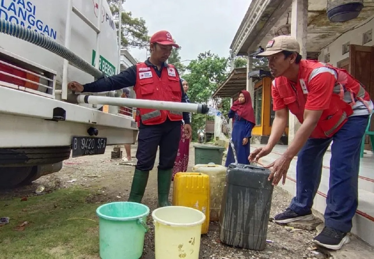 Petugas PMI Jember saat mendistribusikan air bersih kepada warga yang membutuhkan pasca banjir bandang di Kecamatan Sumberjambe, Kabupaten Jember, Jawa Timur. SP/ JBR
