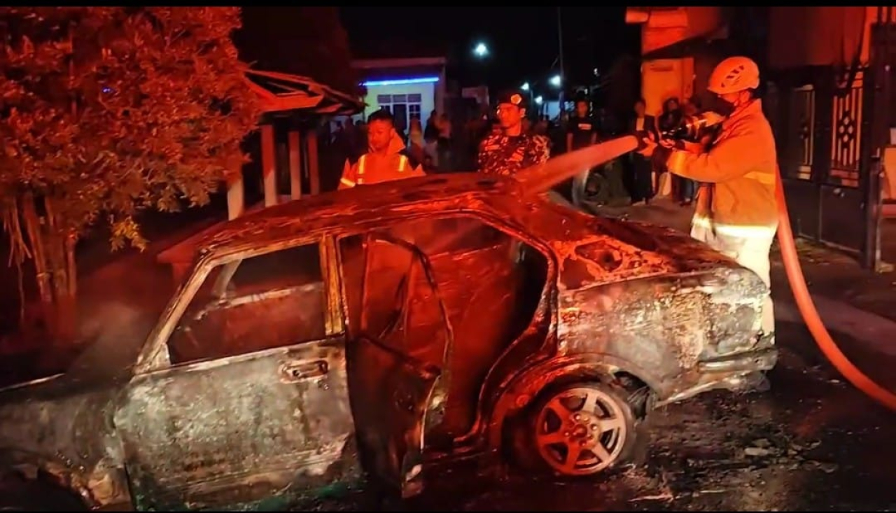 Petugas pemadam saat berupaya memadamkan api yang membakar badan mobil. SP/Lestariono