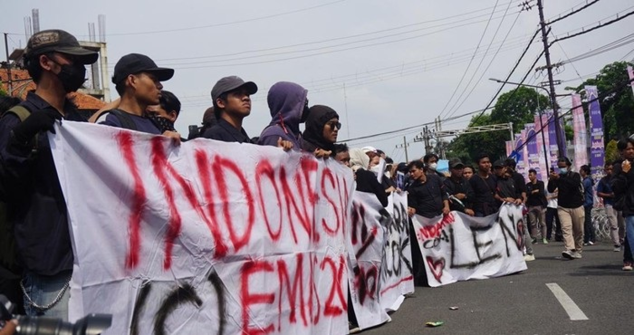 Massa pendemo Indonesia gelap membacakan puisi di DPRD Jatim, Jumat (21/2/2025). Mereka membaca puisi berjudul 'Taek' sambil membakar ban. Aksi ini diwarnai bakar ban di depan gedung DPRD Jatim.