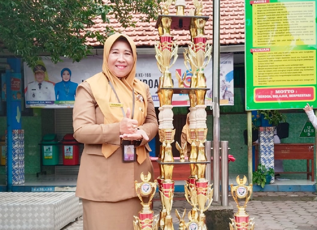Rukianah SPd, MPd. Kasek SDN Pagerwojo berpose bersama Piala setinggi 2 meter. SP/ HANDOKO