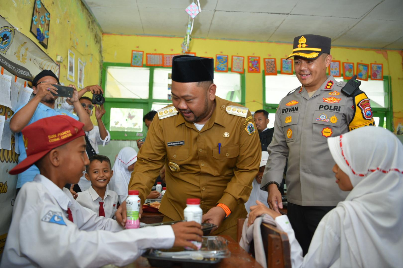 Bupati Fandi Akhmad Yani dan Kapolres AKBP Rovan Richard Mahenu dengan riang gembira membagikan MBG kepada siswa-siswi SDN-71 Cerme. SP/M Aidid