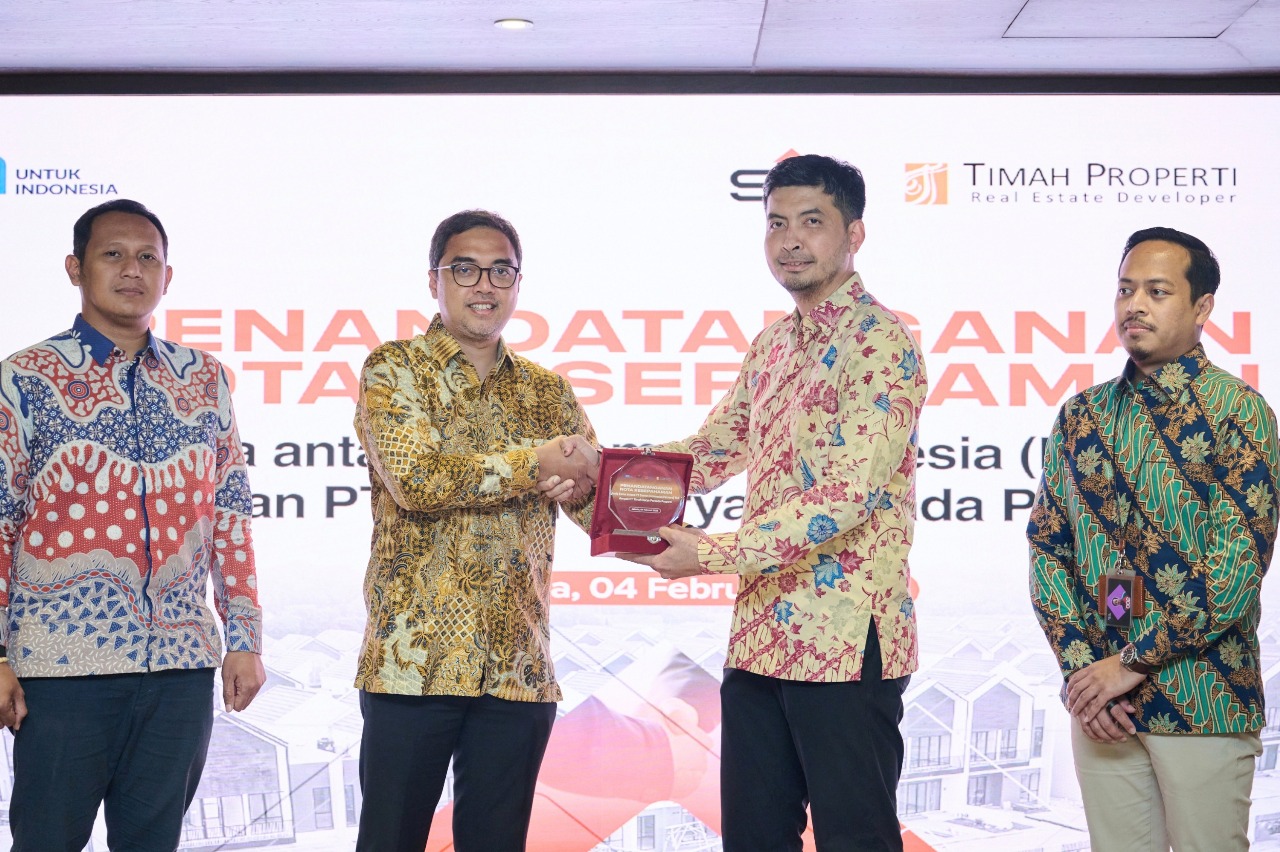 SVP of Business Innovation SIG, Andi Krishna Arinaldi (kedua kiri) menyerahkan cendera mata kepada Direktur Utama TKPP, Abdul Kamaroes pada acara Penandatanganan Nota Kesepahaman kerja sama penyediaan solusi bahan bangunan dan jasa konstruksi di Kantor Pu