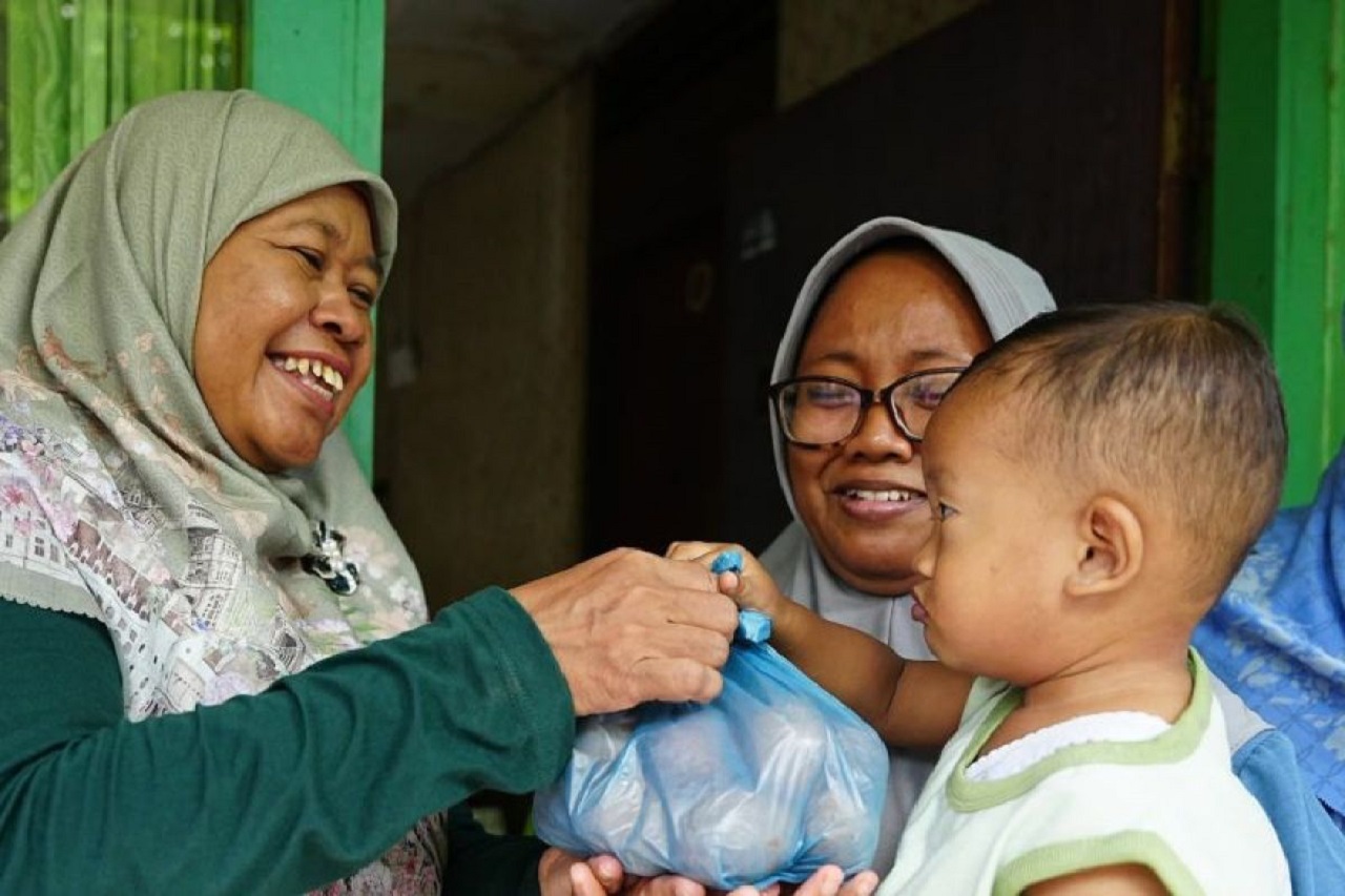 Kepala Dinkes PPKB Kota Madiun Denik Wuryani (kiri) memberikan bantuan telur ayam 1 kilogram secara langsung kepada anak dengan kasus stunting di Kota Madiun. SP/ MDN