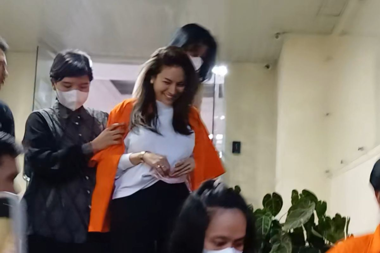 Momen Nikita Mirzani, dengan memakai baju tahanan berwarna orange, berjalan bersama asistennya, IM, menuju tahanan Polda Metro Jaya.