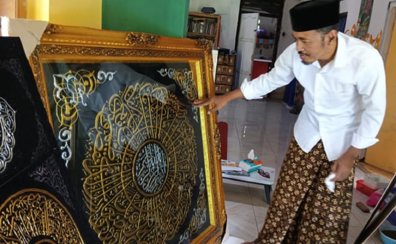 Salah satu perajin, Komarudin yang sedang menunjukkan kaligrafi hasil karyanya. SP/ TLG
