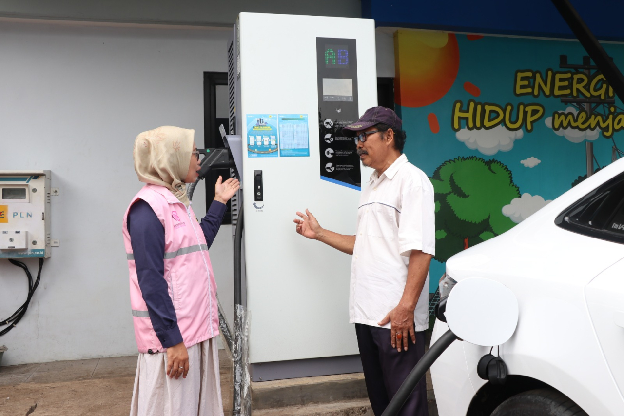 Estuning Rahayu (kiri), Srikandi PLN ketika melayani pelanggan yang hendak mengisi daya kendaraan listrik pada periode arus balik mudik lebaran 1446 H. Foto/Humas PLN