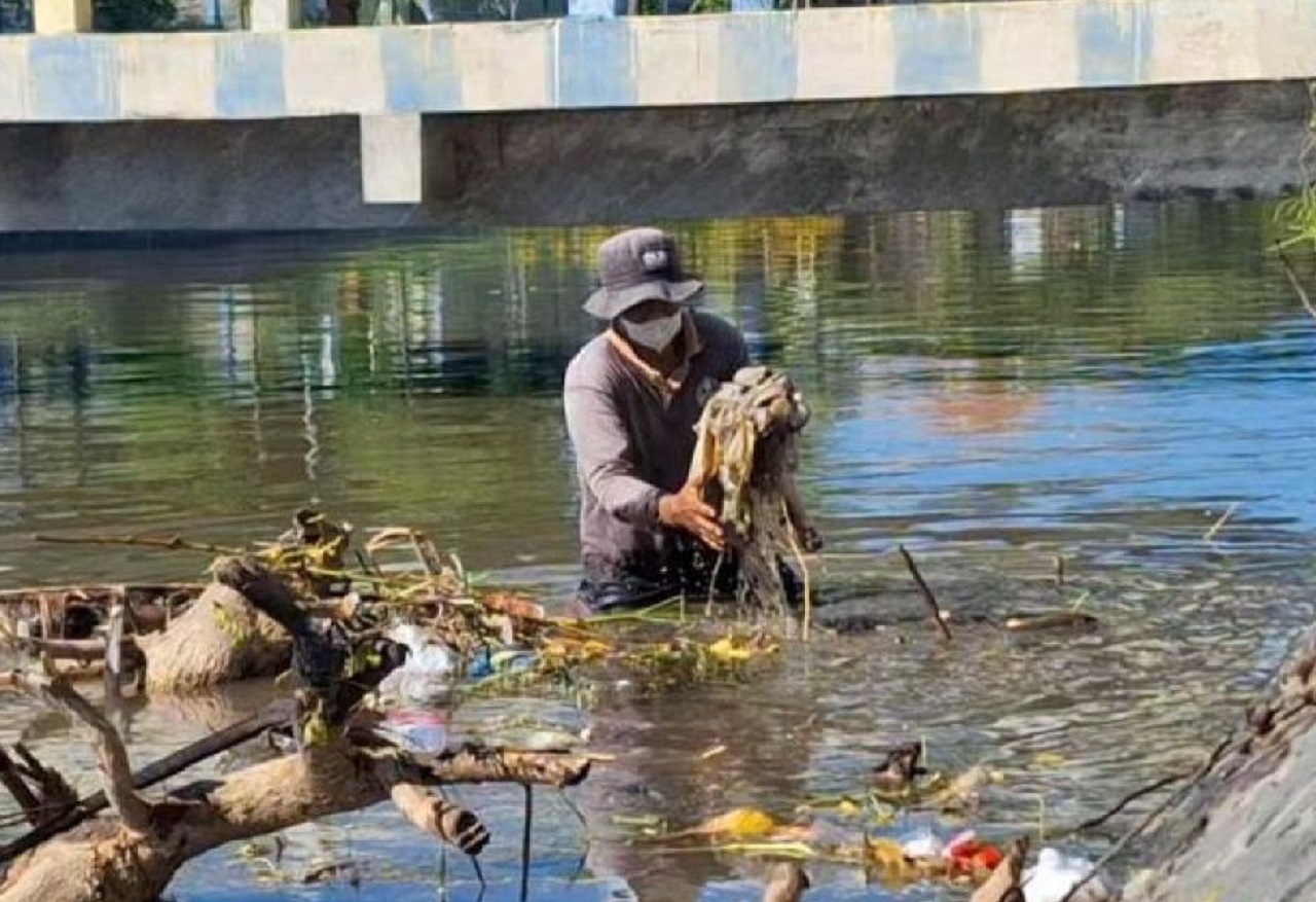 Misri, tenaga honorer Dinas Lingkungan Hidup Kabupaten Situbondo, Jawa Timur, masih bekerja membersihkan sampah di sungai kawasan perkotaan. SP/ STB