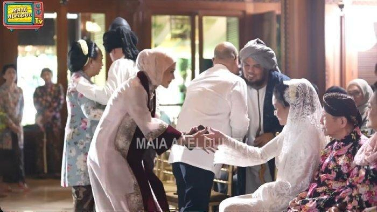 Momen Mulan Jameela saat bersalaman dengan Maia Estianty, yang posisinya duduk, ketika menghadiri pernikahan Al Ghazali dengan Alyssa Daguise.