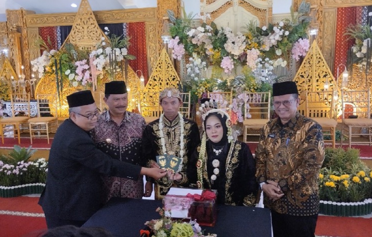 Sebanyak enam pasangan pengantin peserta kegiatan nikah massal bertajuk Madiun Mantu 2025 berfoto bersama Wali Kota Madiun Maidi. SP/ MDN