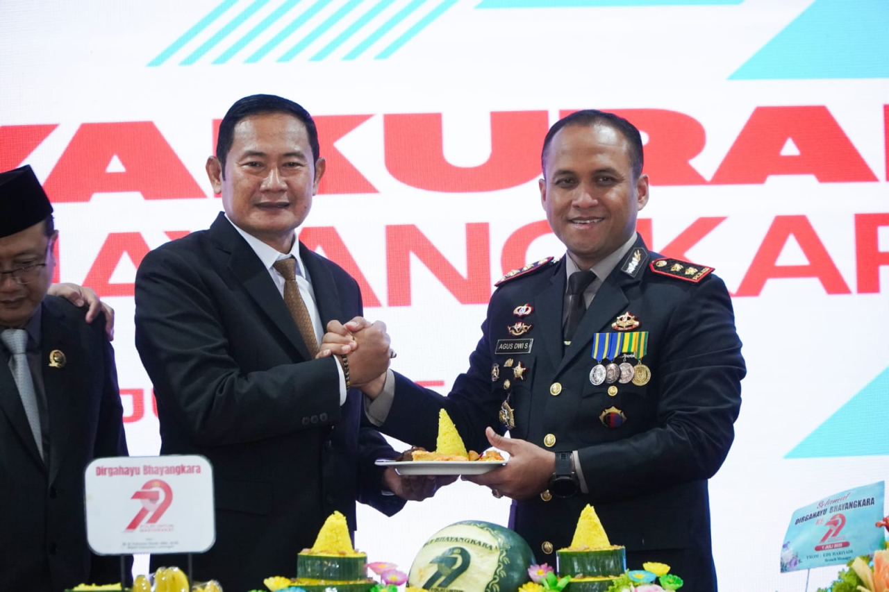 Bupati Lamongan saat menyerahkan potongan tumpeng ke Kapolres AKBP Agus Dwi Suryanto dalam tasyakuran HUT Bhayangkara ke 79 di Pendopo Lokatantra setempat. SP/MUHAJIRIN 