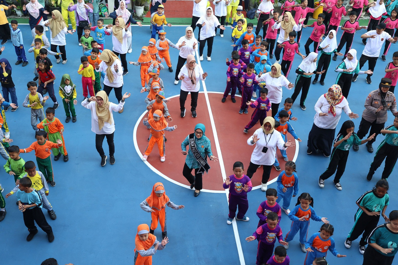 Bunda PAUD Kota Surabaya Rini Indriyani saat senam pagi bersama ratusan siswa PAUD, TK dan SD pada acara Pertemuan Pagi Ceria dalam rangka memperingati Hari Anak Nasional (HAN) Tahun 2025 di SDN Kedung Baruk.