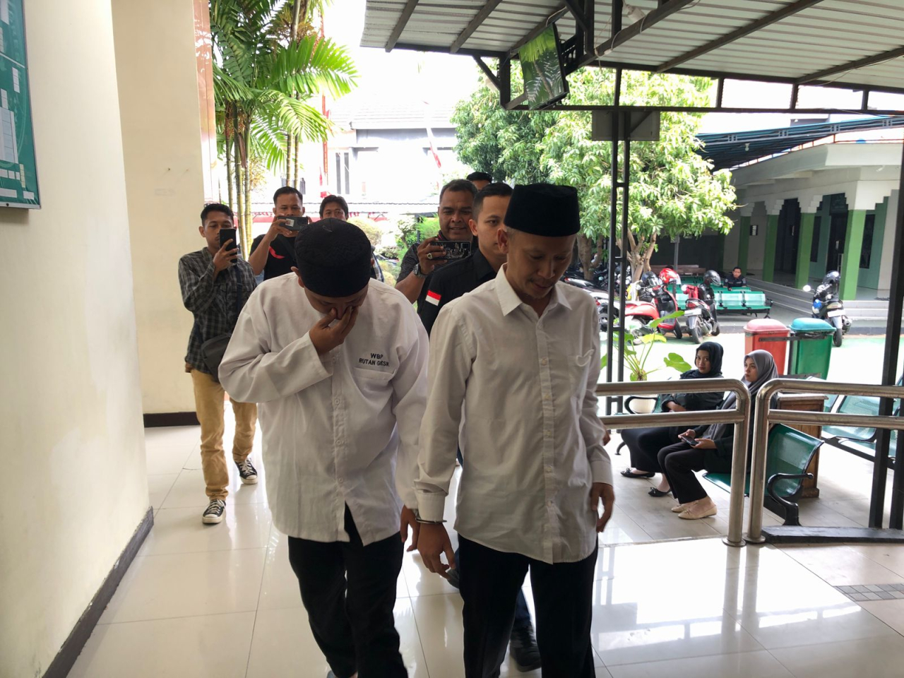 Dua tersangka kasus dugaan pemalsuan dokumen tanah saat digelandang ke ruang sidang PN Gresik.