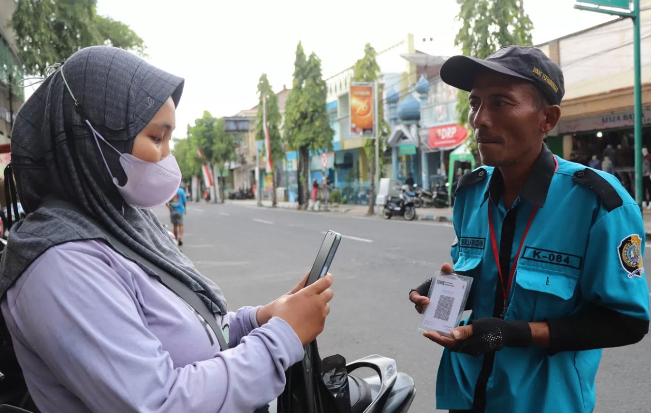 Ilustrasi. Pelanggan membayar retribusi nontunai kepada juru parkir di Jalan Pangeran Diponegoro beberapa waktu lalu. SP/ TLG