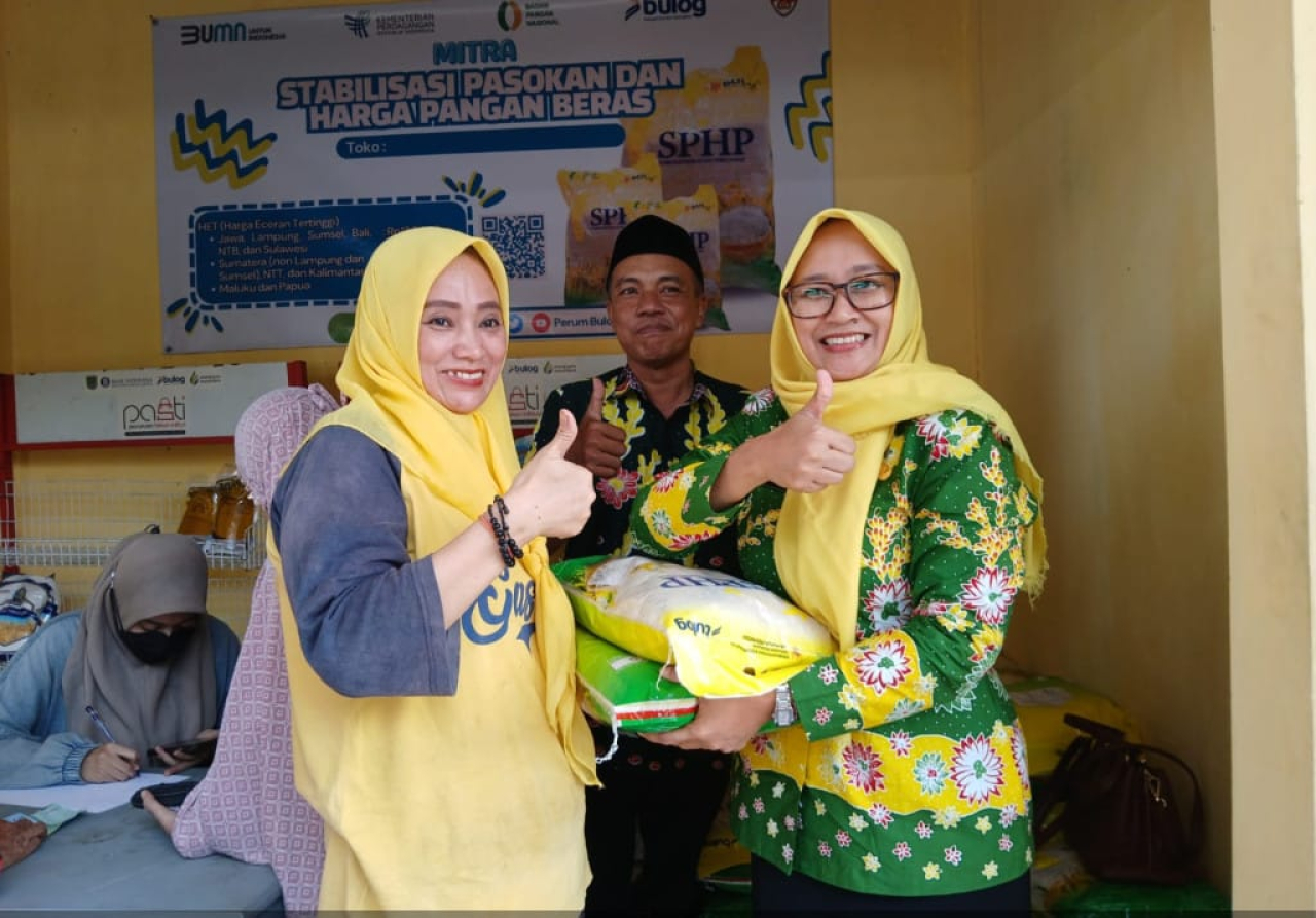 Plt Kepala Disperindag Kabupaten Pasuruan, Mita Kristiani saat memberikan beras SPHP ke salah satu warga di pasar Sukerejo.