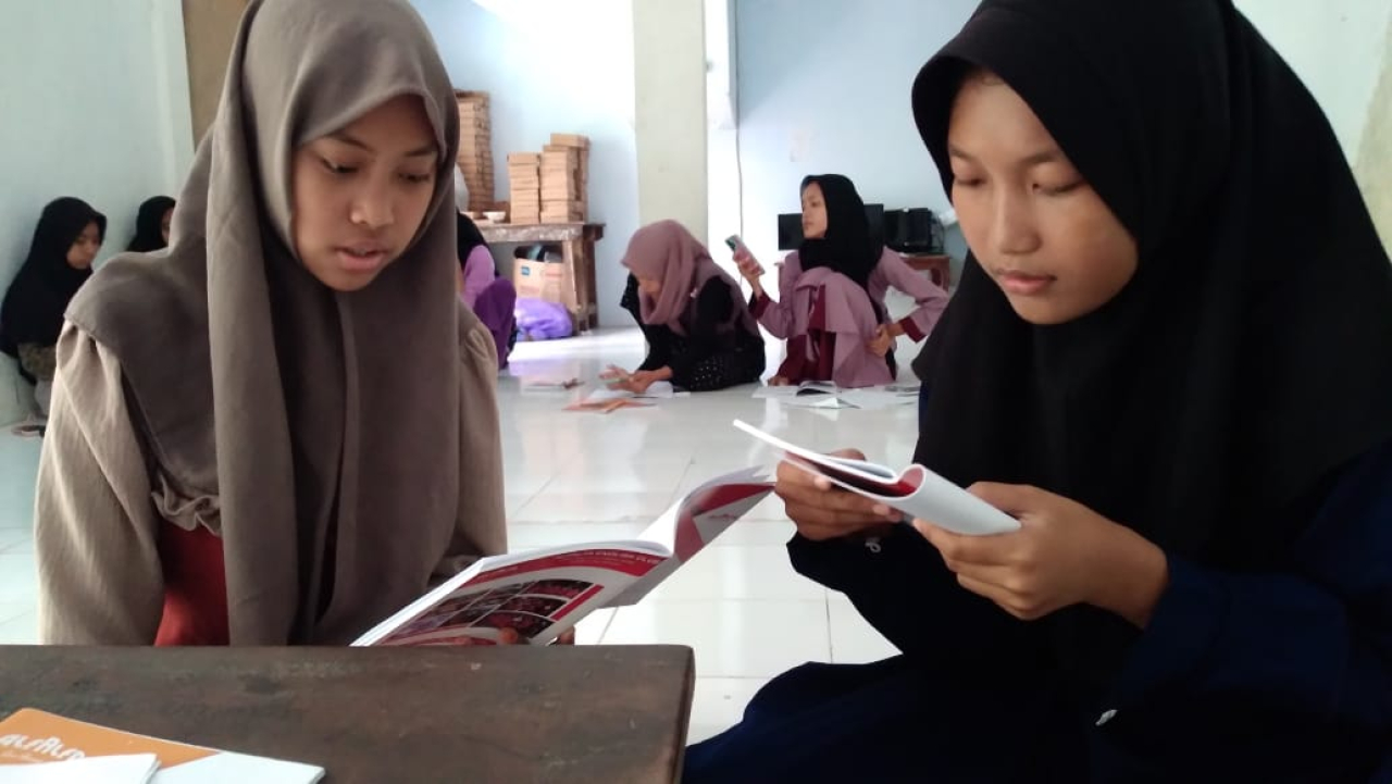 Dua siswi saat terpantau tengah membaca buku yang baru diterimanya. SP/IST