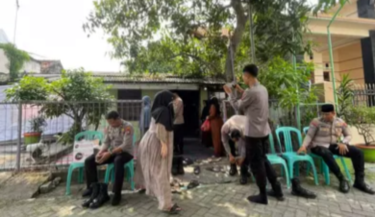 Aparat kepolisian saat berjaga di sekitar rumah duka sambil menunggu kedatangan jenazah.  FOTO:SP/MUHAJIRIN