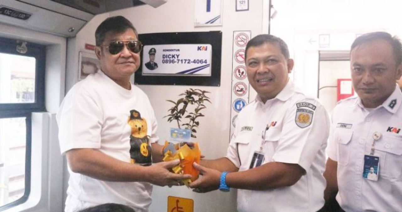 Manajer Humas Daop 7 Madiun Rokhmad Makin Zainul membagikan bibit tanaman hias kepada penumpang KA yang hendak berangkat dari Stasiun Madiun. SP/ MDN