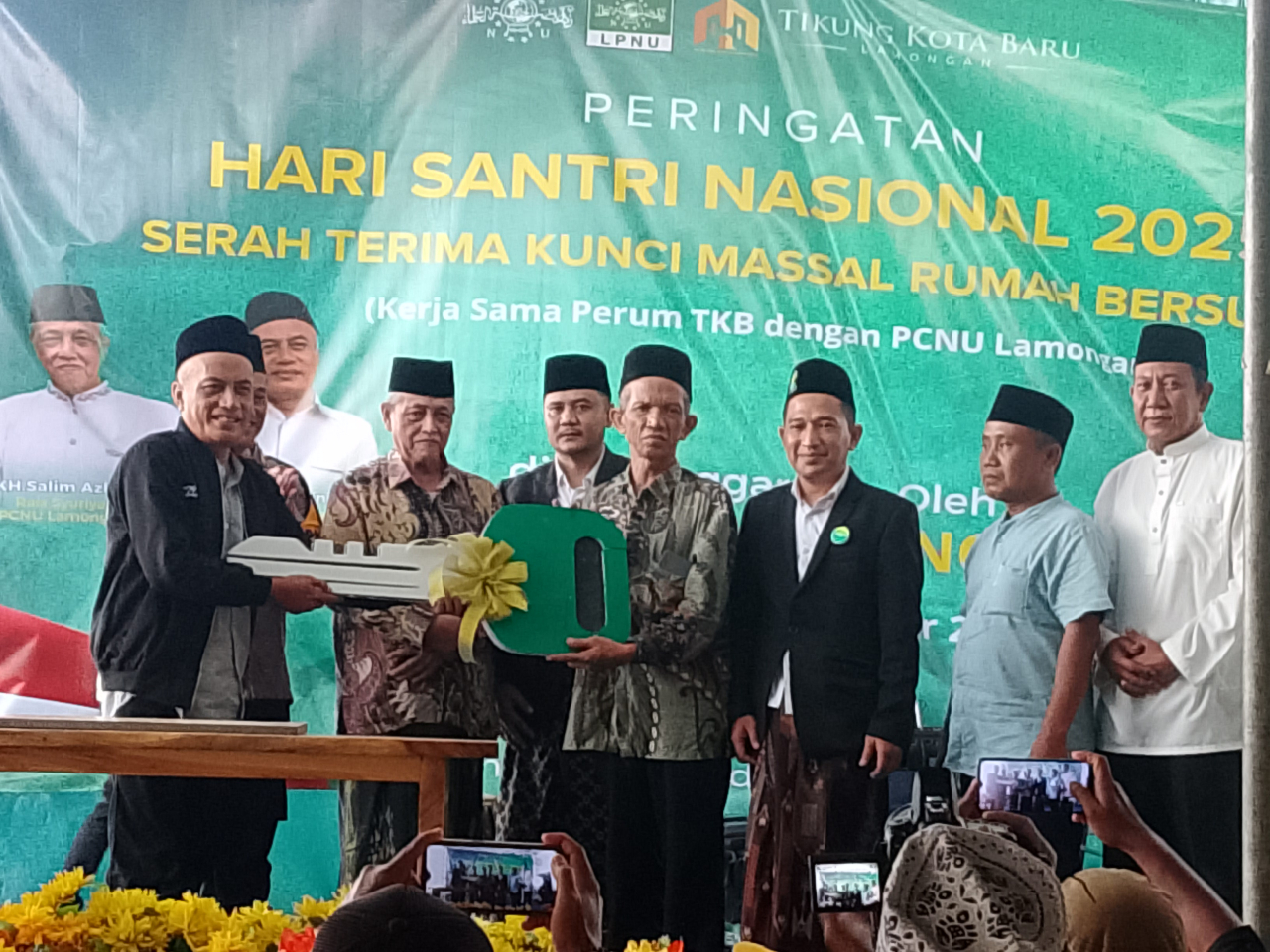 Ketua Tanfidziah Gus Syahrul Munir didampingi Rais Syuriyah PCNU Lamongan KH. Salim Ashar didampingi menyerahkan kunci rumah ke salah satu perwakilan warga Nahdlatul Ulama.  FOTO:SP/MUHAJIRIN