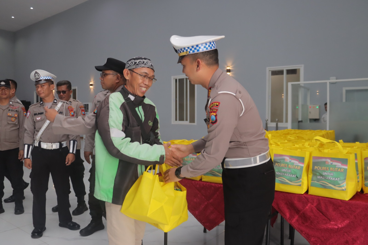 Polisi memberikan bantaun kepada salah satu driver ojol saat kegiatan berlangsung. SP/Lestariono