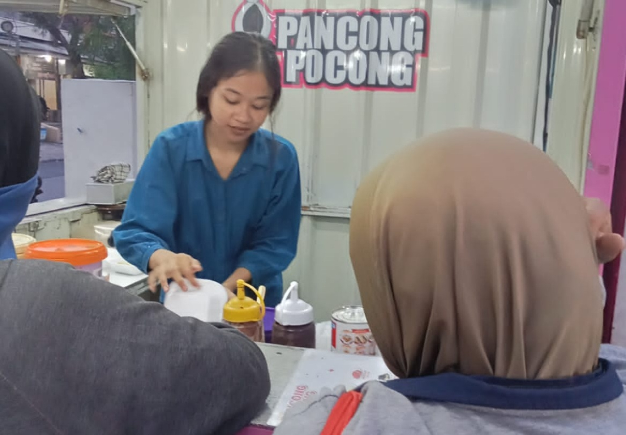 Entrepreneur kue Pancong berlogo Pocong yang berlokasi di sekitar wilayah Petemon Kali Kecamatan Sawahan, Surabaya. SP/ HIKMAH