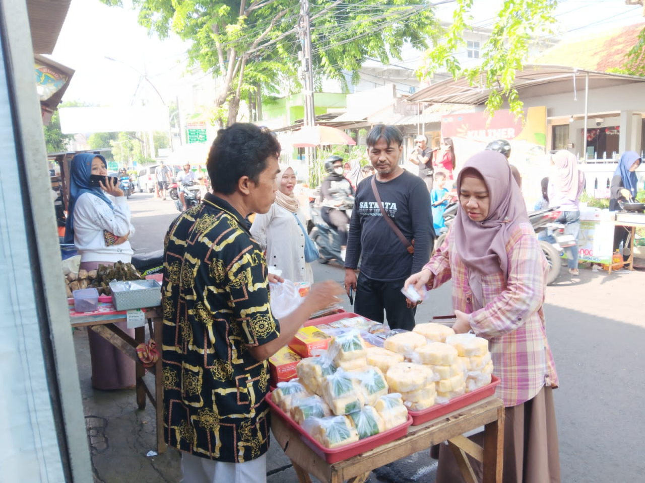 Anggota DPRD Gresik Elvita Vetty ikut berbelanja di stan Kuliner Jajan Trate yang digelar Kartar Kelurahan Trate, Kecamatan Gresik, Ahad (16/11/2025). SP/ MAIDID