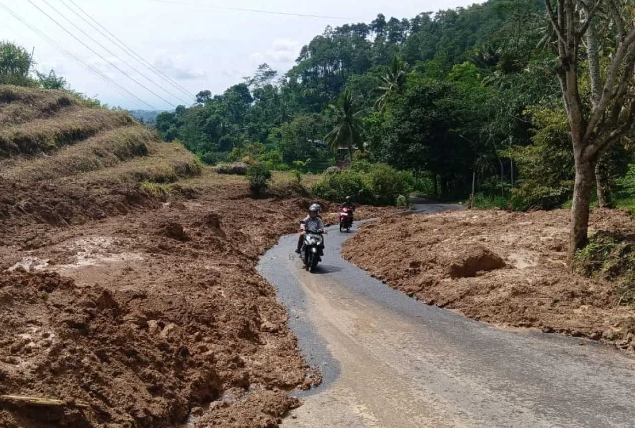 Salah seorang pemotor melintasi jalan terdampak longsor pasca normalisasi di ruas jalan Desa Kradinan, Tulungagung, Jawa Timur. SP/ TLG