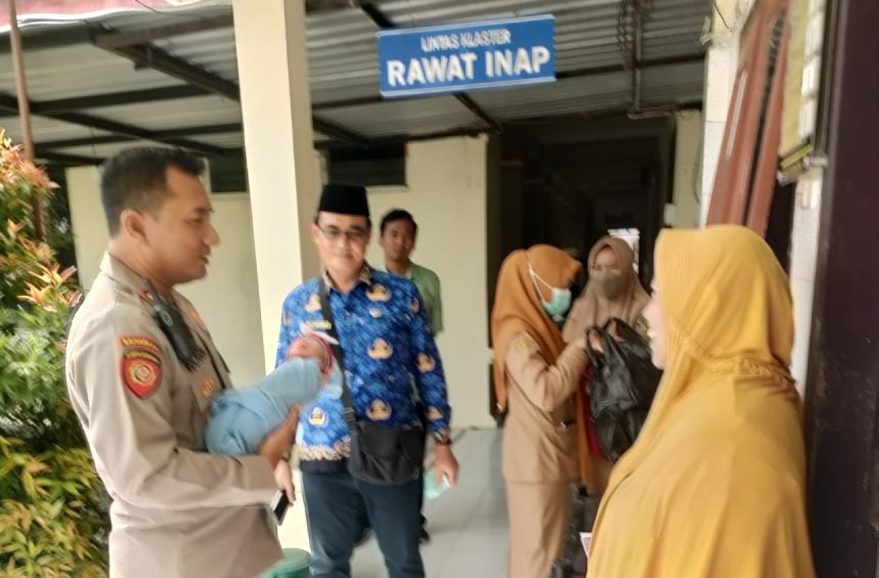 Kapolsek Udanawu AKP Ahmad Roichan saat menyerahkan bayi tersebut ke Pihak RSUD Srengat. SP/ Lestariono