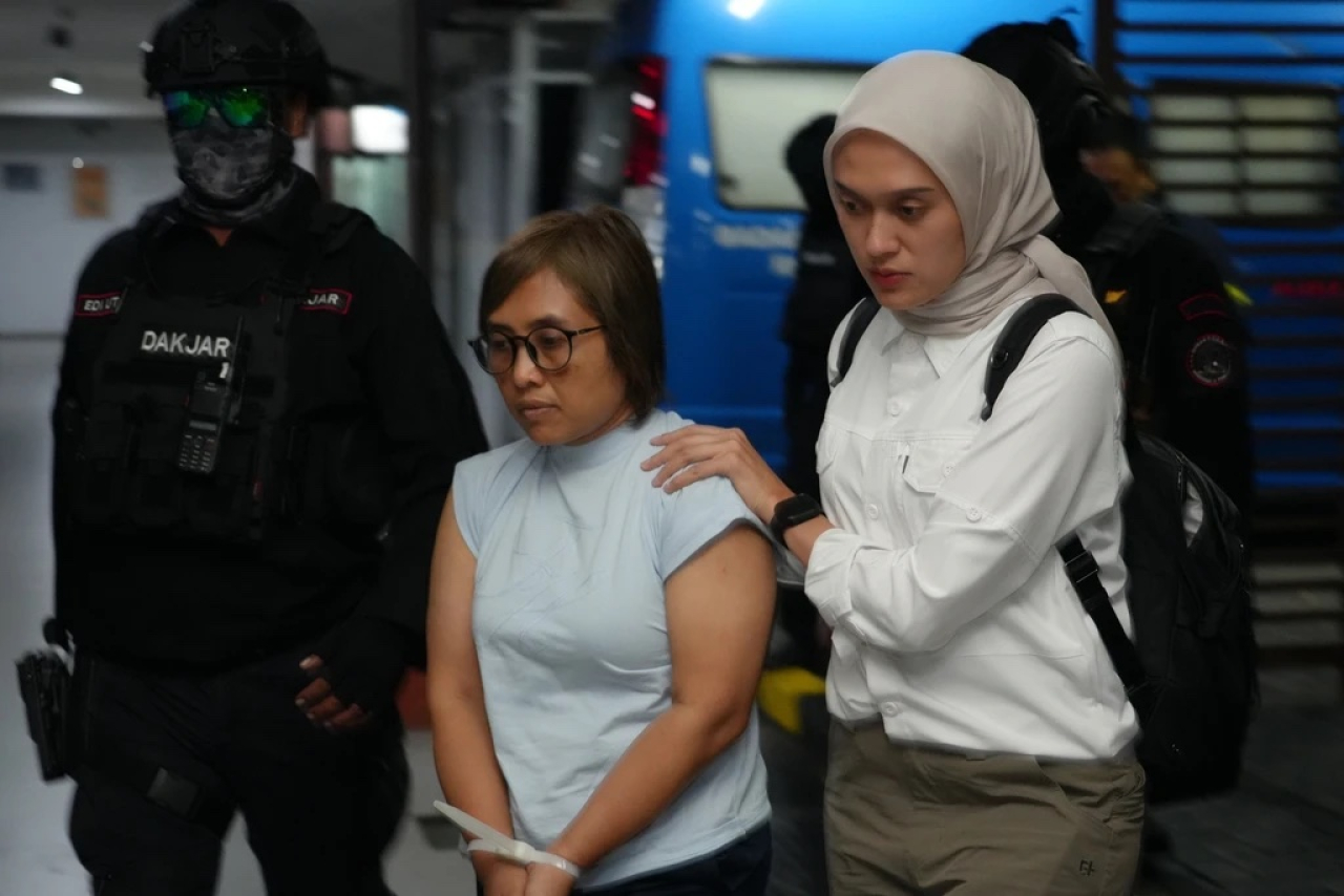 Petugas Badan Narkotika Nasional (BNN) menggiring buronan internasional asal Indonesia Dewi Astutik alias Mami alias Dinda (tengah) setibanya dari Kamboja di Bandara Soekarno Hatta, Tangerang, Banten, Selasa (2/12/2025).