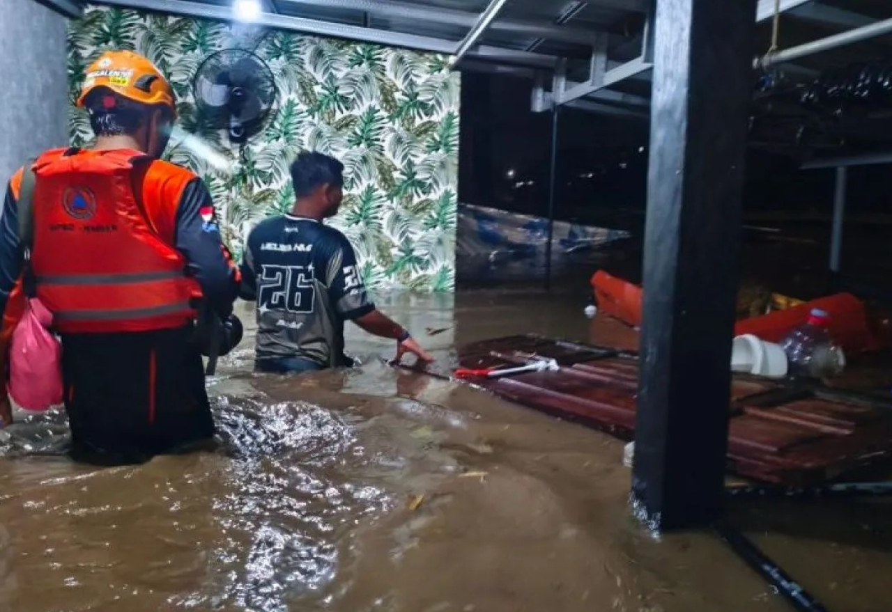 Petugas BPBD Jember mengevakuasi warga saat banjir menerjang pemukiman warga di salah satu perumahan di Jember, Jawa Timur. SP/ JBR