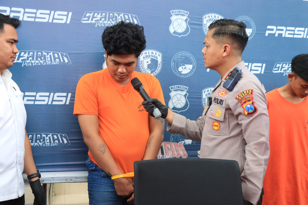 Kapolres Gresik AKBP Rovan Richard Mahenu berbincang dengan seorang anggota gangster yang sudah ditangkap saat menggelar konferensi pers, Jumat (9/1). SP/Maidid