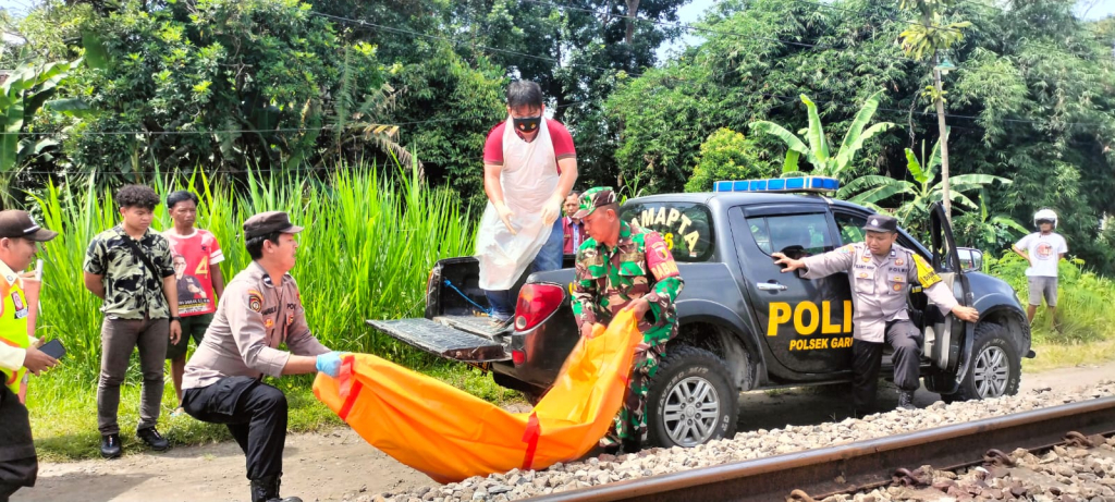 Petugas saat mengevakuasi jenazah korban yang tercerai berai usai tertabrak KA. SP/Lestariono