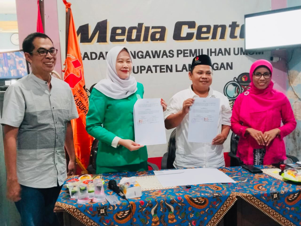 Ketua PC Fatayat dan Bawaslu menunjukan berkas kerjasama MoA usai penandatangan. SP/MUHAJIRIN