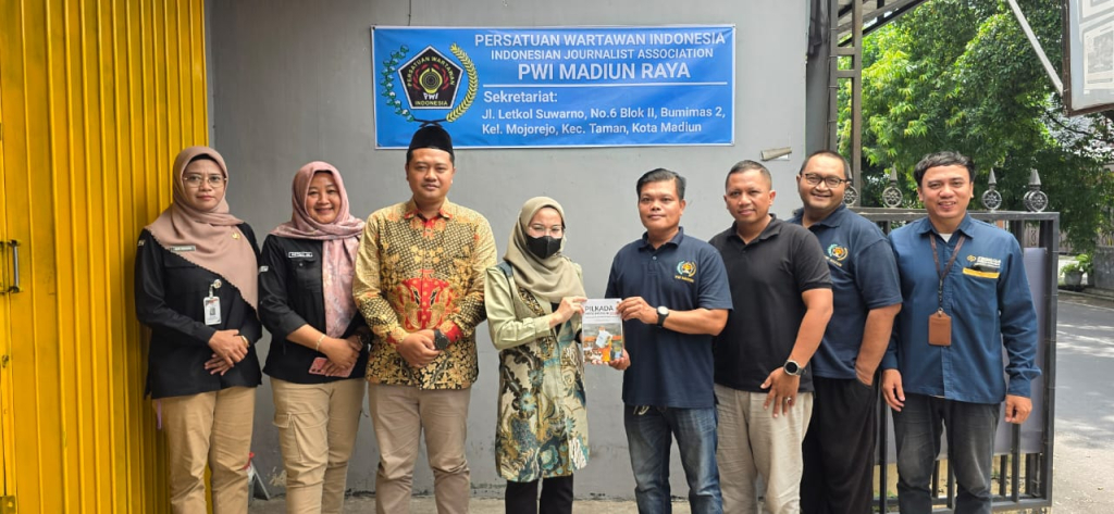 Ketua KPU Kota Madiun Pita Anjarsari (tengah) bersama jajaran menyerahkan buku “Pilkada Kota Madiun 2024: Tantangan, Strategi dan Evaluasi” kepada Ketua PWI Madiun Raya Jumali. SP/ Istimewa