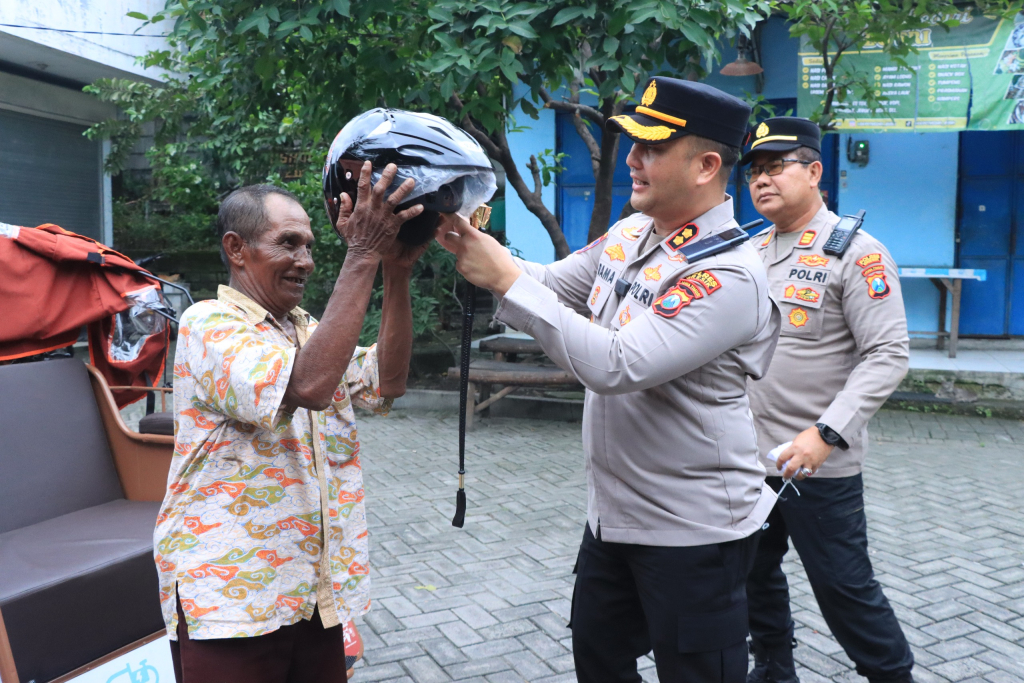 Kapolres Gresik AKBP Ramadhan Nasution turun langsung ke lapangan untuk membagikan helm gratis kepada para pengemudi becak listrik di Kecamatan Manyar, Rabu (4/2/2026).