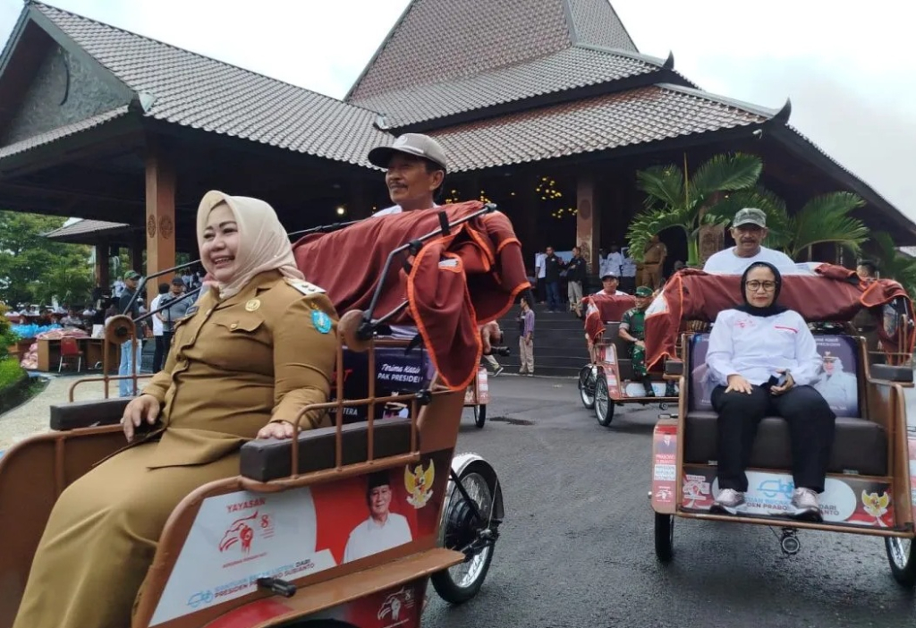 Wakil Ketua Yayas(kanan) an Gerakan Solidaritas Nasional Naniek S. Deyang bersama Plt. Bupati Ponorogo Lisdyarita (kiri, depan) mencoba becak listrik bantuan Presiden Prabowo Subianto. SP/ PNG