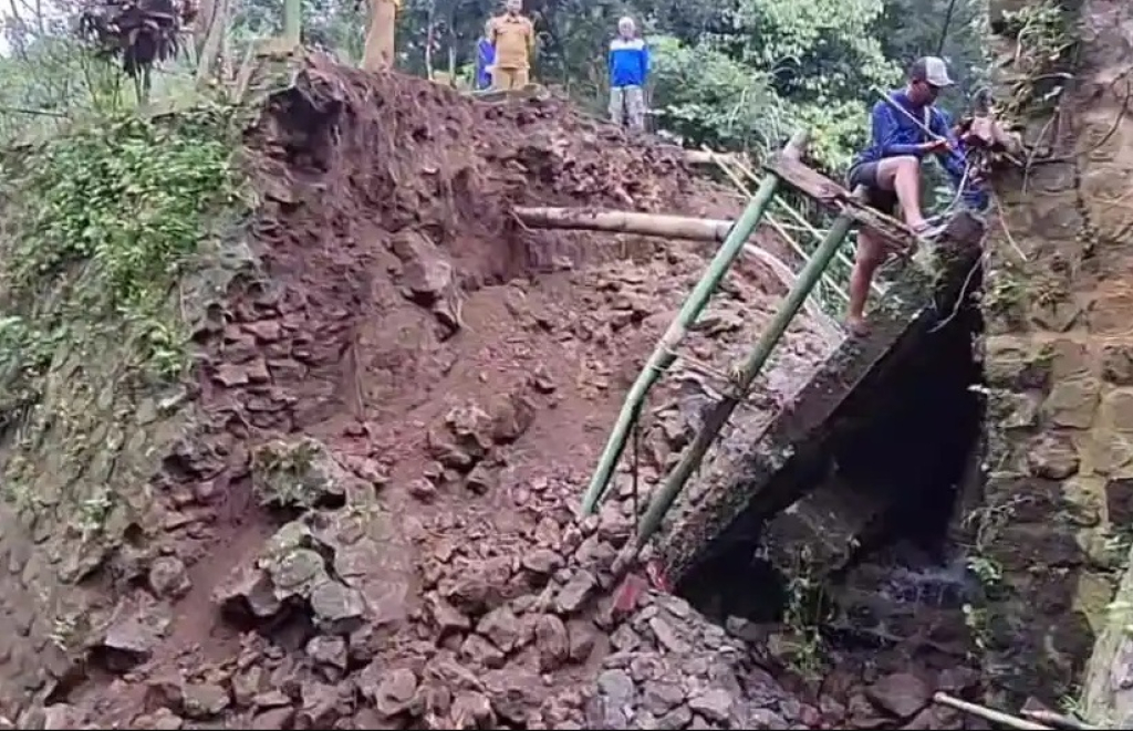 Sejumlah warga dan petugas desa memantau jembatan di Desa Ngrambe, Kecamatan Ngrambe, Kabupaten Ngawi, Jatim, yang roboh hingga mengganggu aktivitas warga desa setempat. SP/ NGW