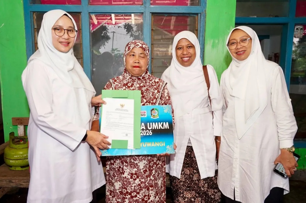 Bupati Banyuwangi Ipuk Fiestiandani menyerahkan bantuan modal usaha program Warung Naik Kelas kepada salah seorang penerima di Kecamatan Wongsorejo, Banyuwangi. SP/ BYW