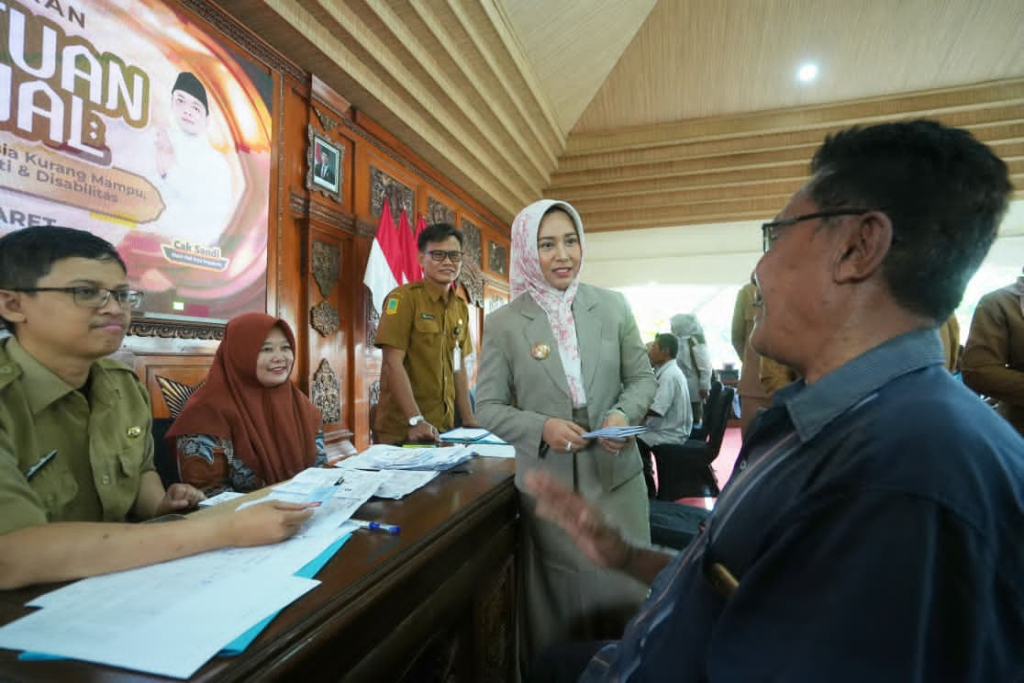 Wali Kota Mojokerto, Ika Puspitasari saat membagikan bantuan sosial (bansos) berupa uang tunai kepada 294 tukang becak kurang mampu. SP/ DWI